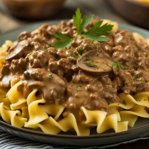 Easy ground beef stroganoff with egg noodles, creamy mushroom gravy, and parsley garnish