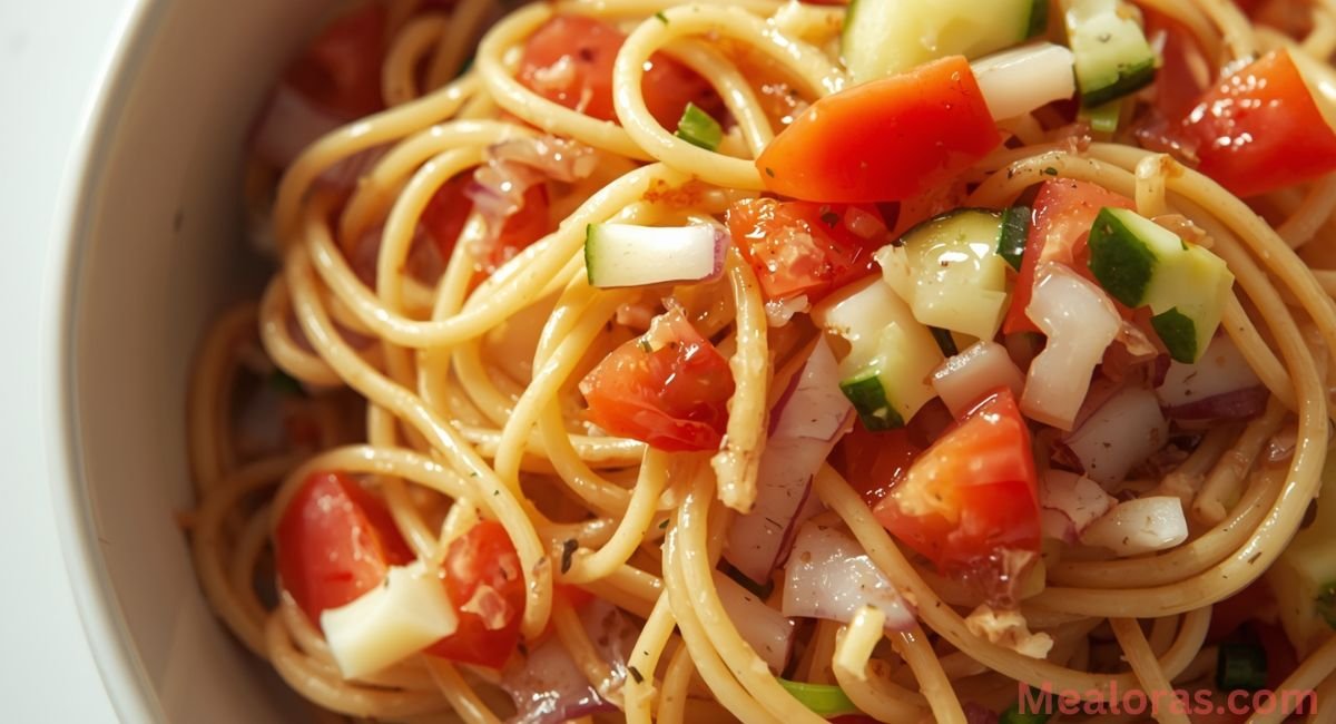 spaghetti and chopped vegetables tossed with italian dressing in large mixing bowl