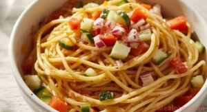classic spaghetti salad with italian dressing and fresh vegetables served chilled