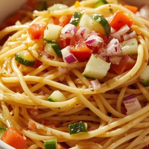 classic spaghetti salad with italian dressing and fresh vegetables served chilled