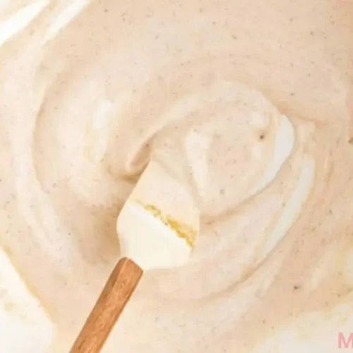 Creamy Elote Dressing in a small bowl with cotija cheese and lime wedge