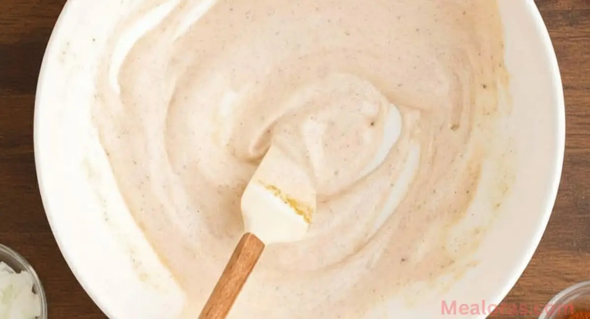 Creamy Elote Dressing in a small bowl with cotija cheese and lime wedge