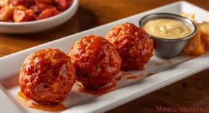 Crispy Hot Cheetos Boudin Balls on a serving plate with dipping sauce