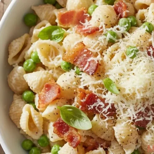 Creamy pasta salad with bacon, peas, and parmesan in a bowl