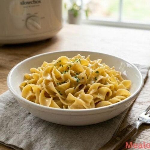 A steaming plate of glossy, buttery egg noodles served alongside roasted chicken breast and fresh green vegetables, capturing a complete, non-alcoholic family dinner